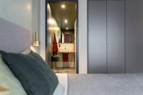 a bedroom with a bed and a bathroom with a sink at ipartment Berlin Airport in Schönefeld