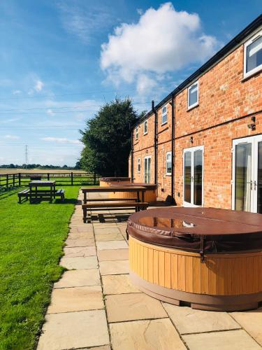 a brick building with tables and benches in the grass at Murton Grange in York