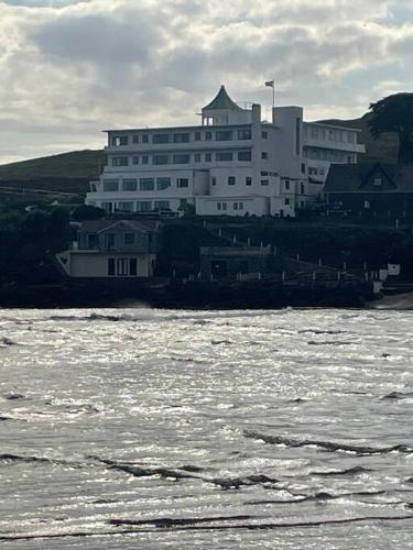 a large white building next to a body of water at Bumble Bee Cottage in Plymouth