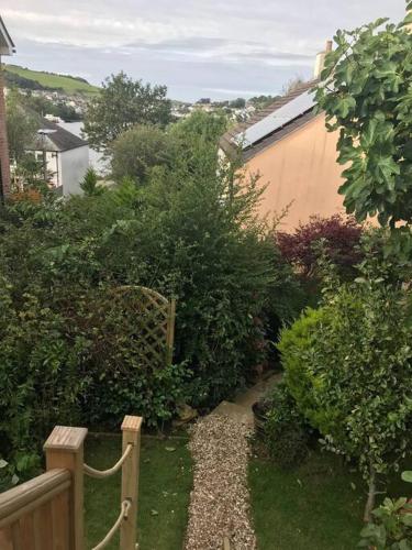 a garden with a wooden fence and some bushes at Bumble Bee Cottage in Plymouth