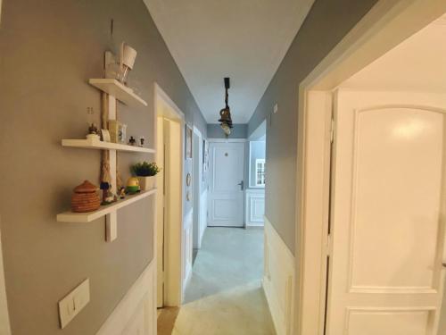 un pasillo con una puerta blanca y estanterías en la pared en Cozy Apartment (JANNA) en 6th Of October