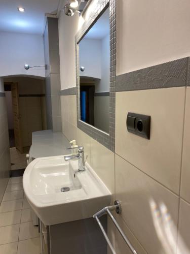 ein Bad mit einem Waschbecken und einem Spiegel in der Unterkunft Apartament Przy Ratuszu in Kłodzko