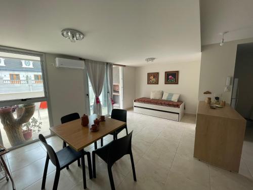 a living room with a table and chairs and a bed at Amplio departamento céntrico Plaza Belgrano in San Salvador de Jujuy