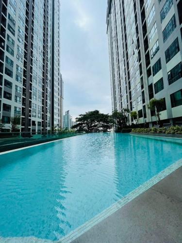 a large blue swimming pool with tall buildings at The base Central Pattaya 631 by Numam in Pattaya Central