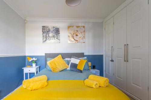 a bedroom with a blue and yellow bed with yellow pillows at West Hill Stays Chapel Alleton LS7 - 3 bed Sleeps 5 - close to City Center - free parking - contractor welcome in Moortown
