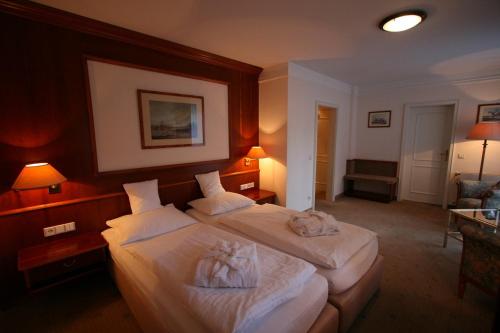 a hotel room with two beds with towels on them at Park Hotel am Schloss in Ettringen