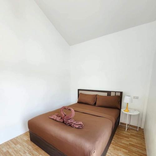 a bed with a pair of pink shoes on it at DOO KHAO in Ban Chong Tako