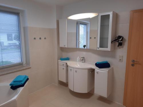 a white bathroom with a sink and a mirror at Ferienwohnung Orient in Liepgarten