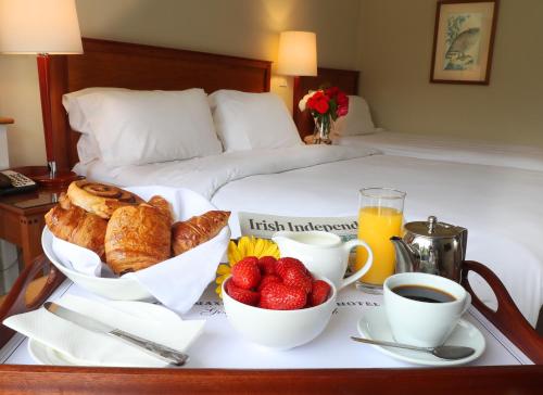 a breakfast tray with fruit and croissants on a bed at Ballymascanlon Hotel and Golf Resort in Dundalk