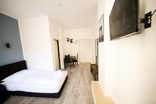 ein Schlafzimmer mit einem weißen Bett und einem Tisch in der Unterkunft LUXOMES: Aparthotel Nürnberg Zentrum Süd in Nürnberg
