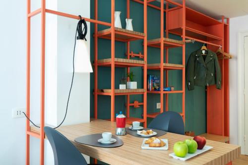 a dining room with a table and a shelf at Hotel Piazza Bellini & Apartments in Naples