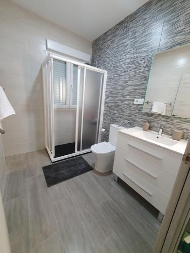 a bathroom with a shower and a toilet and a sink at Melania House in Candeleda