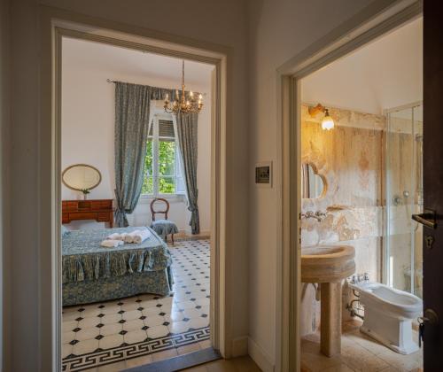 a bedroom with a bed and a bathroom with a shower at Villa Le Querciolaie in Monteverdi Marittimo