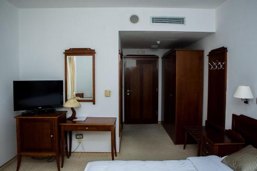 Una televisión o centro de entretenimiento en Hotel Hum