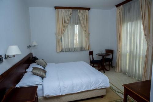 1 dormitorio con 1 cama, mesa y sillas en Hotel Hum en Ljubuški