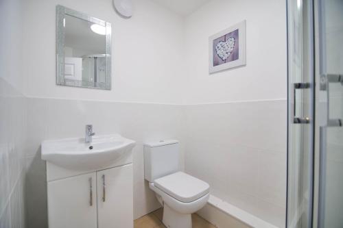 a white bathroom with a toilet and a sink at Murton Grange in York