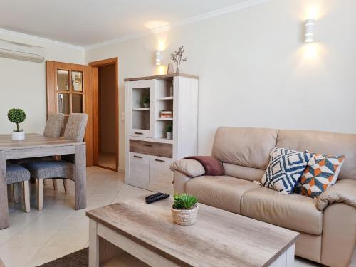 ein Wohnzimmer mit Sofa und Tisch in der Unterkunft SÍTIO DO RAPOSO - Carvoeiro - WiFi, AC, Beach & Center 200m in Carvoeiro