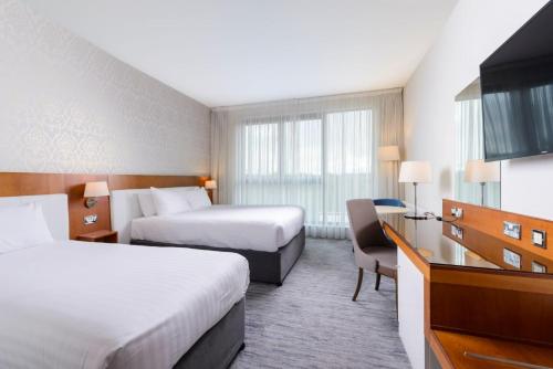 a hotel room with two beds and a desk at The Ellison in Castlebar