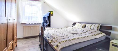1 dormitorio con 1 cama y TV en FeWo Finkenberg Freudenstadt, en Freudenstadt