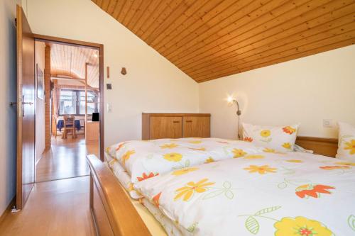 una camera con un grande letto e un soffitto in legno di Ferienwohnung Camilla Wagner ad Amtzell