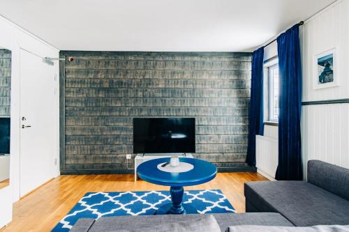 a living room with a blue table and a tv at Hotell Karolinen Åre in Åre