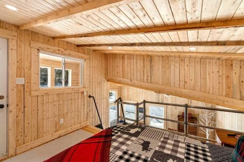 Cabaña con cama en una habitación con paredes de madera en Cozy Cabin for Intimate Wilderness Escape, en Bathurst