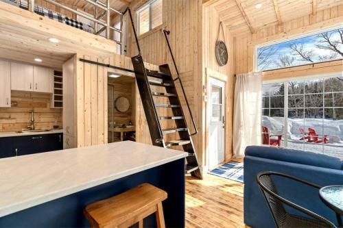 eine Küche und ein Esszimmer eines winzigen Hauses in der Unterkunft Cozy Cabin for Intimate Wilderness Escape in Bathurst