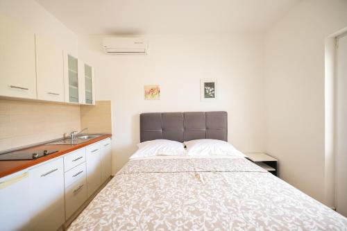 Apartments Marina في بيتريتشاني: غرفة نوم بسرير ومغسلة