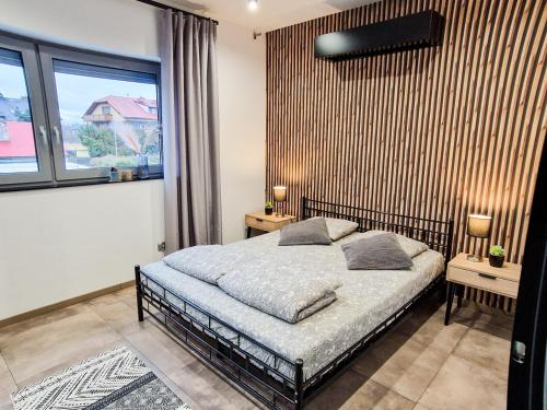 a bedroom with a bed and a large window at Apartament LOFT in Pszczyna