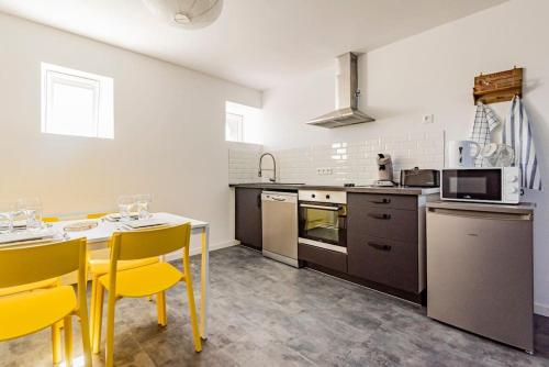 d'une cuisine avec une table et des chaises jaunes. dans l'établissement Duplex LUTON 4, à Reims