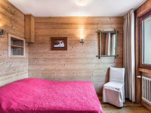 - une chambre avec un lit rose et une chaise dans l'établissement Appartement Charmant 2 Pièces, Centre de Megève, 3 Pers., Garage, 3 Étoiles - FR-1-453-106, à Megève