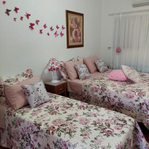 two beds in a room with butterflies on the wall at Recanto Panapaná - suítes in Águas de São Pedro