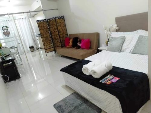 - un salon avec un lit et un canapé dans l'établissement Elize Wind Residences, à Tagaytay