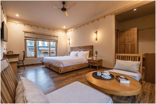 a hotel room with two beds and a table at essence AT LADAKH in Leh