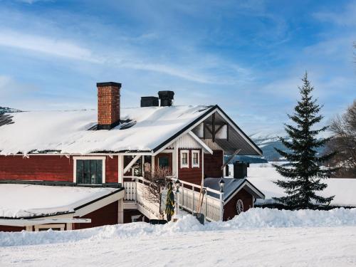 a house covered in snow with a christmas tree at Hotell Karolinen Åre in Åre