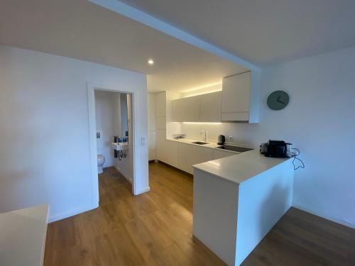 a kitchen with white cabinets and a white counter top at XENON PRIME Urban Apartments in Maputo