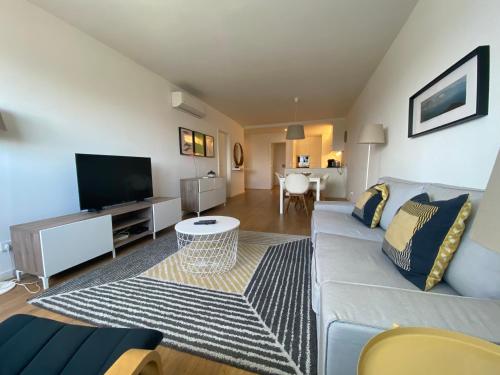 a living room with a couch and a flat screen tv at XENON PRIME Urban Apartments in Maputo