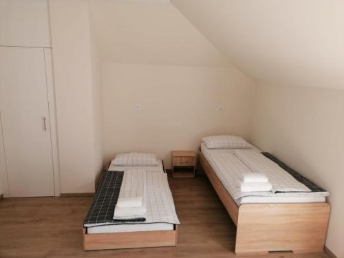 two beds in a small room with wooden floors at Appartement Design 2 in Altenstadt