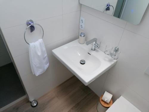 a white bathroom with a sink and a mirror at Appartement Design 2 in Altenstadt