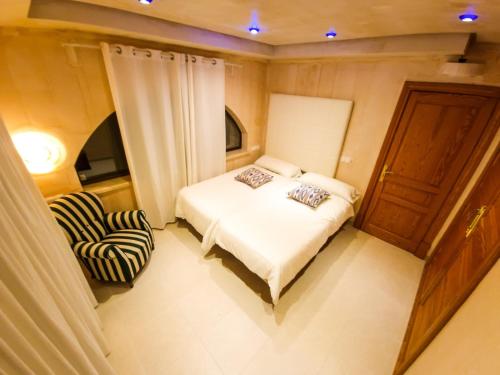 um pequeno quarto com uma cama e uma cadeira em Villa Cala Llamp em Andratx