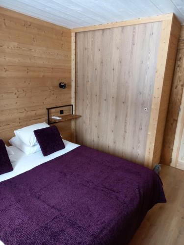 a bedroom with a bed with a purple blanket at Eco-Logis des Cabris in Font-Romeu