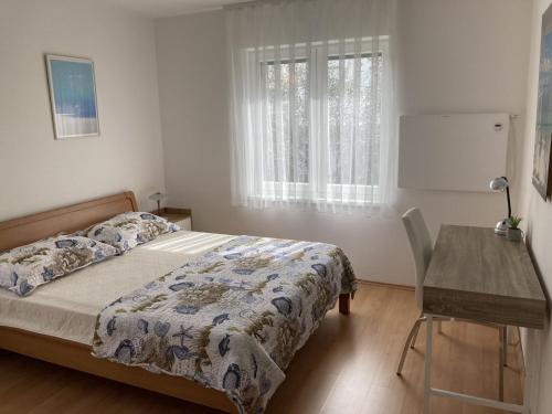 een slaapkamer met een bed, een tafel en een raam bij Apartment Valens in Poreč