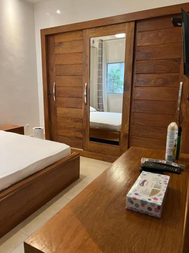 1 dormitorio con cama, mesa y espejo en Résidence La Renaissance de Dakar, en Ouakam
