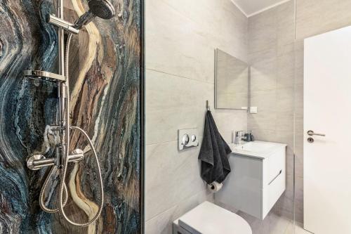 uma casa de banho com um chuveiro e um WC. em Casa do Porto em Paul do Mar
