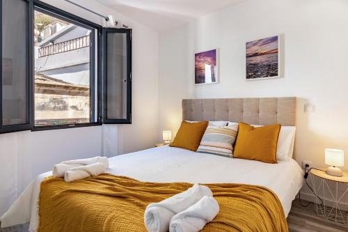 una camera da letto con un letto grande con cuscini gialli di Casa do Porto a Paul do Mar