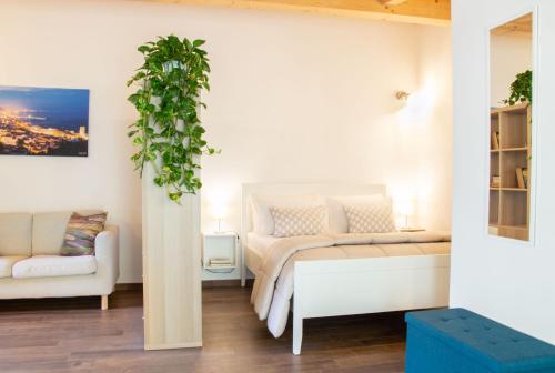 een slaapkamer met een wit bed en een bank bij Dépendance 6 in Salerno