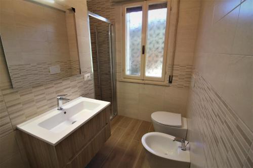 bagno con lavandino, servizi igienici e finestra di Villa Mary a Lignano Sabbiadoro
