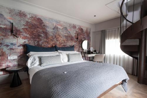 een slaapkamer met een groot bed en een trap bij Soho Boutique Palacio de Pombo in Santander