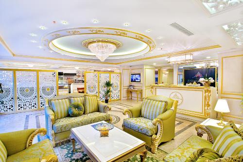 una sala de estar con muebles de color amarillo y una lámpara de araña. en Emirhan Palace Hotel, en Estambul