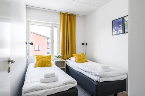 two beds in a room with a window at Hiisi Homes Kirkkonummi Laajakallio in Kirkkonummi